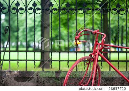 Red bicycle at the fence of the old park Red bicycle at the fence of the old park 28637720