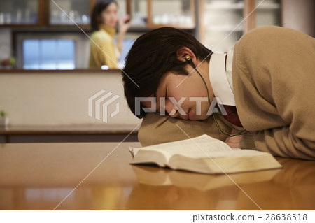 A male sleeping while studying for exams at home 28638318