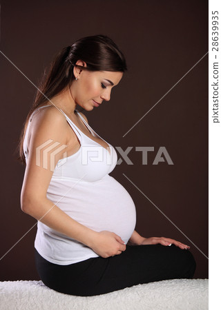 Happy pregnant woman touching her belly Happy pregnant woman touching her belly 28639935