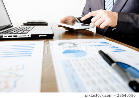 Multitasking. Handsome young man working with touchpad while sit Multitasking. Handsome young man working with touchpad while sit 28640586