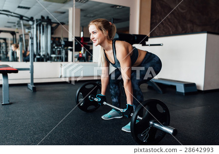 Beautiful fitness woman lifting barbell. 28642993