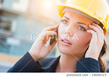 Worried Female Contractor Wearing Hard Hat on Site Using Cell Ph Worried Female Contractor Wearing Hard Hat on Site Using Cell Ph 28646323