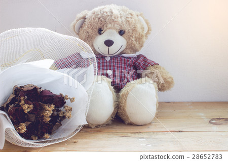 Teddy bear with a bouquet of flowers on the wood 28652783