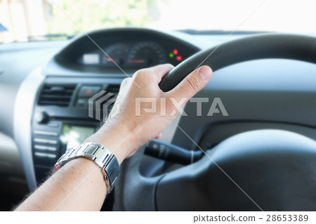 hand holding a steering wheel 28653389
