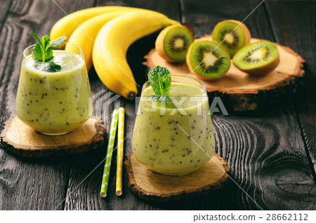 Banana and kiwi smoothie on dark wooden background Banana and kiwi smoothie on dark wooden background 28662112
