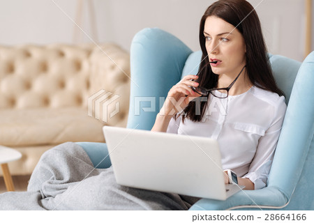 Serious thoughtful woman holding her glasses Serious thoughtful woman holding her glasses 28664166