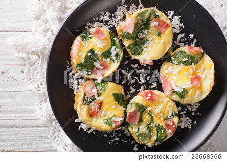 Omelet with spinach, ham and cheese on a plate 28668566