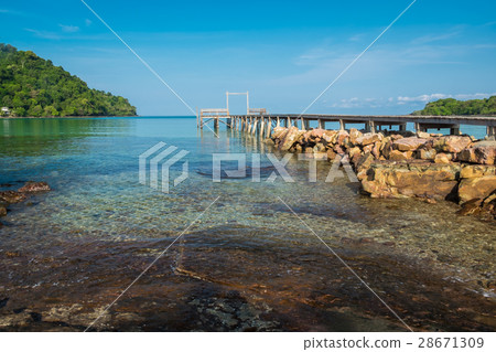 Clear sea water and wooden bridge with rocks 28671309