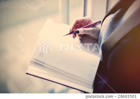 hands holding a notebook and writing some 28683501