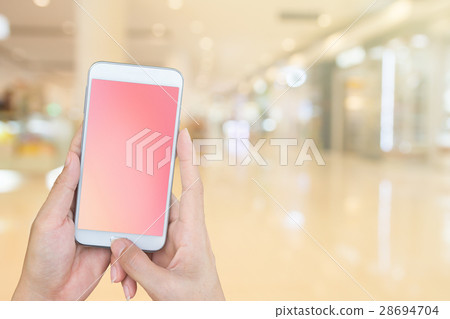 Hand holding smartphone with blur shopping mall 28694704