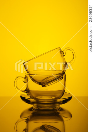 Two transparent glass cups yellow background Two transparent glass cups yellow background 28696534
