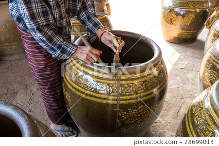 Old famale worker try to fix defects on Dragon Jar 28699013