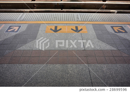 Arrow sign wait electric train behind yellow line 28699596