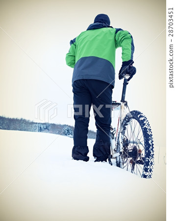 Man with mountain bike stay in powder snow. 28703451