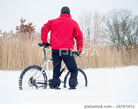 Sportsman with mountain bike lost in snow. Sportsman with mountain bike lost in snow. 28703452