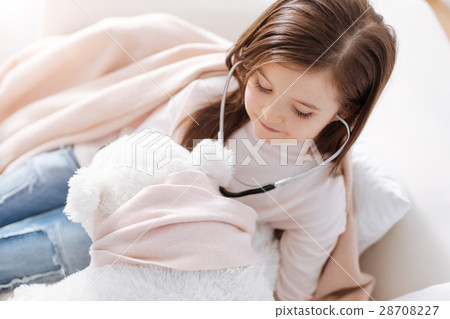 Positive little girl examining fluffy toy with Positive little girl examining fluffy toy with 28708227