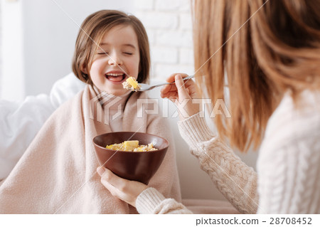 Positive little girl having breakfast with her Positive little girl having breakfast with her 28708452