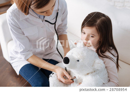 Pleasant doctor examining fluffy toy Pleasant doctor examining fluffy toy 28708954