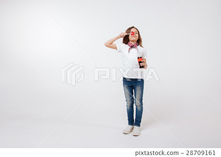 Funny little girl holding bottle and lollipop in 28709161