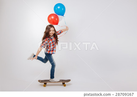 Outgoing girl using skateboard in the studio Outgoing girl using skateboard in the studio 28709167