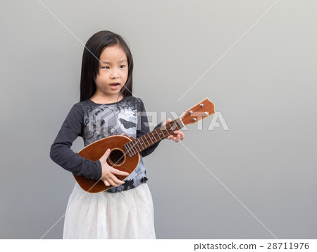 Little asian child play the ukulele Little asian child play the ukulele 28711976
