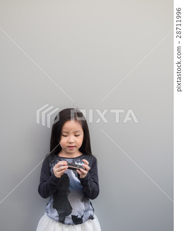 Little asian child play the harmonica 28711996