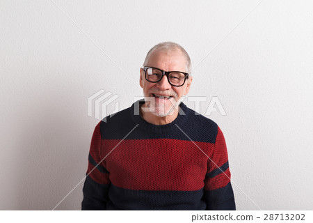 Senior man in red and blue woolen sweater, studio Senior man in red and blue woolen sweater, studio 28713202