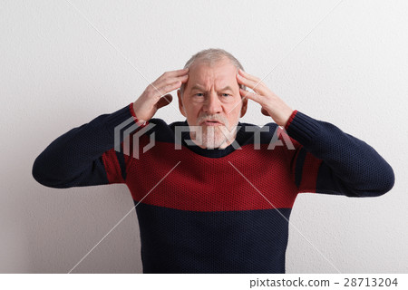 Angry senior man in red and blue sweater, studio Angry senior man in red and blue sweater, studio 28713204