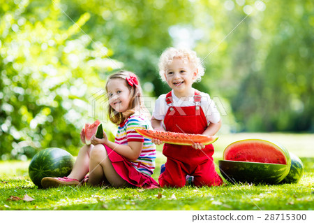 Kids eating watermelon in the garden 28715300