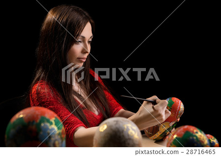 Pretty woman drawing patterns on matrioshka 28716465