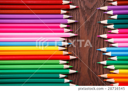 colored pencils on brown wooden background lying 28716545