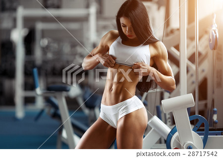 Fitness woman showing abdominal muscles Fitness woman showing abdominal muscles 28717542