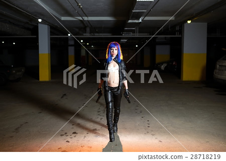 Sexy woman with blue hair holding two guns and looking as killer in underground parking Sexy woman with blue hair holding two guns and looking as killer in underground parking 28718219