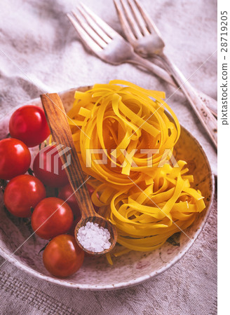 Uncooked tagliatelle pasta with cherry tomatoes 28719205