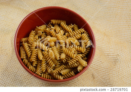 Bowl of dry uncooked whole wheat pasta Bowl of dry uncooked whole wheat pasta 28719701