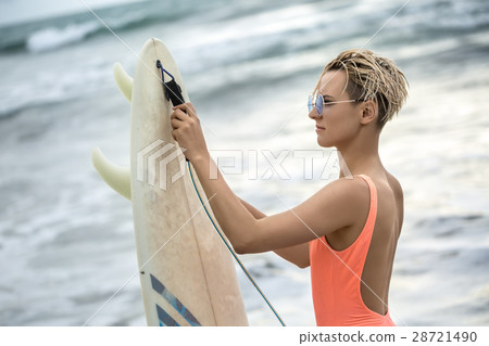 Girl with surfboard on beach 28721490