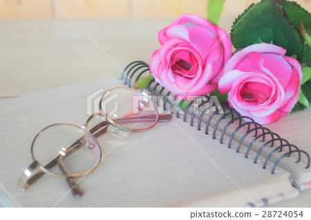 Roses on a notebook with glasses. Roses on a notebook with glasses. 28724054