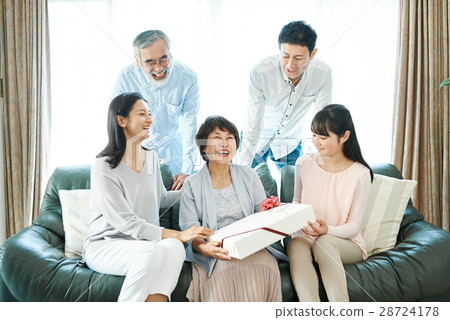 A grandma who gets a present from his / her family 28724178