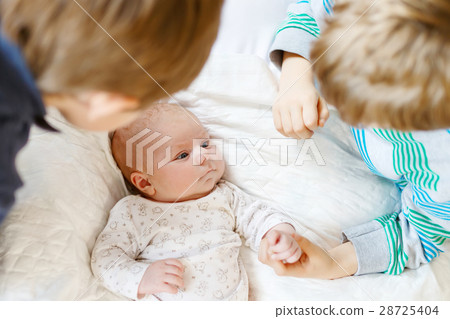 Two little kids boys playing with newborn baby 28725404