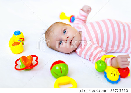 Cute baby girl playing with colorful rattle toys Cute baby girl playing with colorful rattle toys 28725510