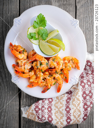 Fried Prawns with lemon served on a wooden surface 28726123