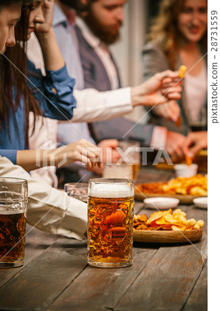 Group of friends enjoying evening drinks with beer Group of friends enjoying evening drinks with beer 28731559