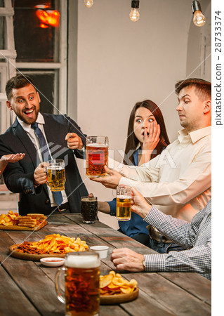 Group of friends enjoying evening drinks with beer Group of friends enjoying evening drinks with beer 28733374