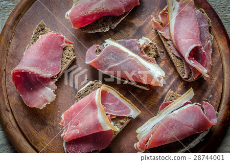 Sandwiches with italian ham on the wooden board Sandwiches with italian ham on the wooden board 28744001