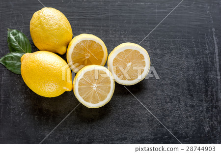 Fresh lemons on the dark wooden background Fresh lemons on the dark wooden background 28744903