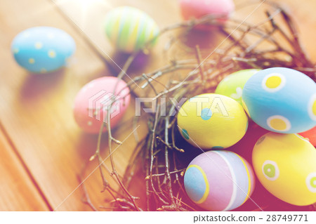 close up of colored easter eggs in nest on wood close up of colored easter eggs in nest on wood 28749771