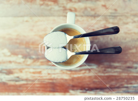 close up of white sugar on teaspoon and coffee cup 28750235