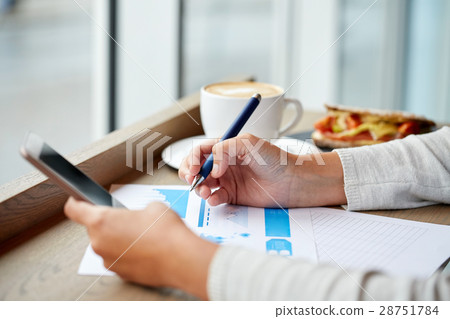 woman with smartphone and chart at cafe 28751784