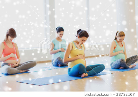 happy pregnant women exercising yoga in gym 28752107