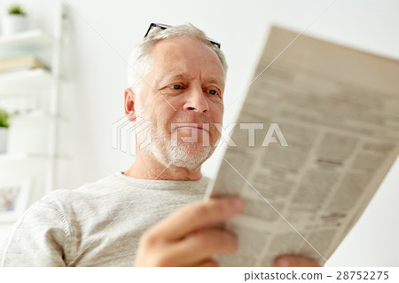 close up of senior man reading newspaper at home 28752275